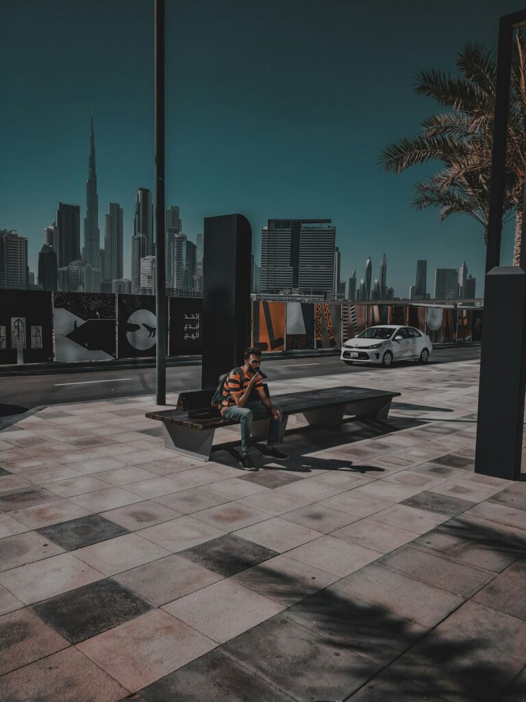 Traveler checking his phone on a Dubai street bench