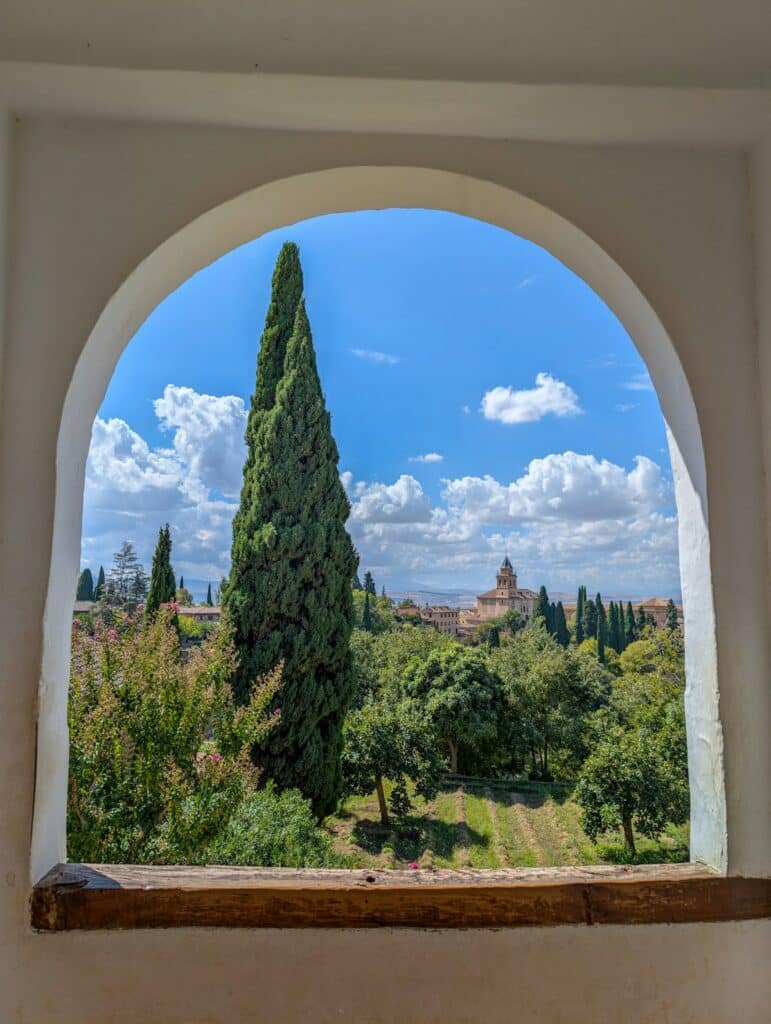 An archway frames a cypress tree in an Andalusian garden