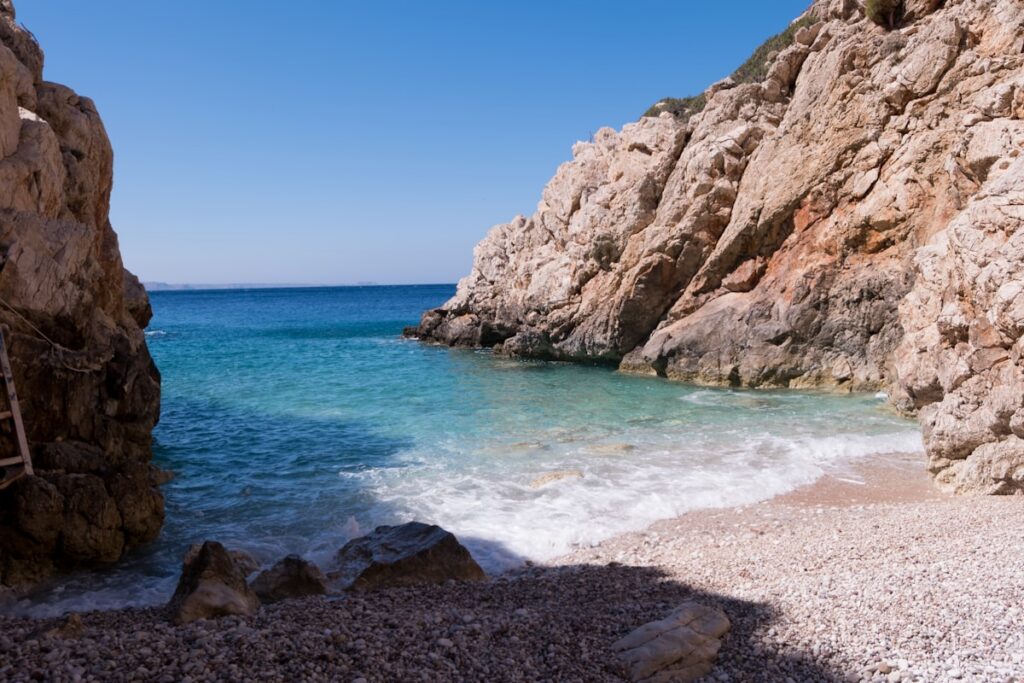 A hidden cove with turquoise water tucked into a Greek island coastline