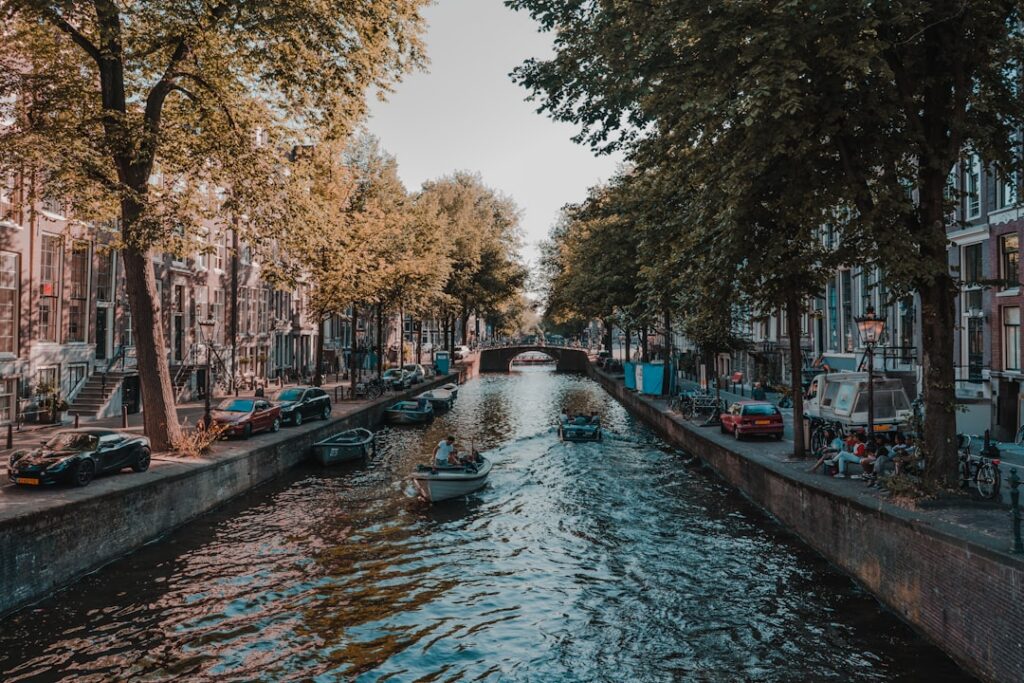 Amsterdam canal lined with traditional houses during the day