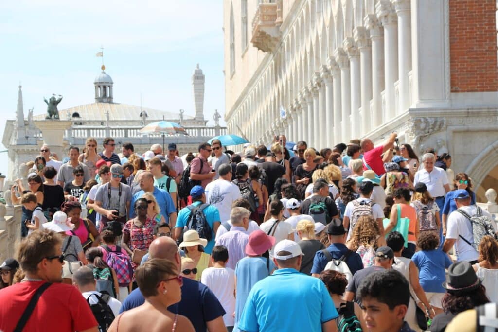 Visitors gathered on a bridge over a Venice canal