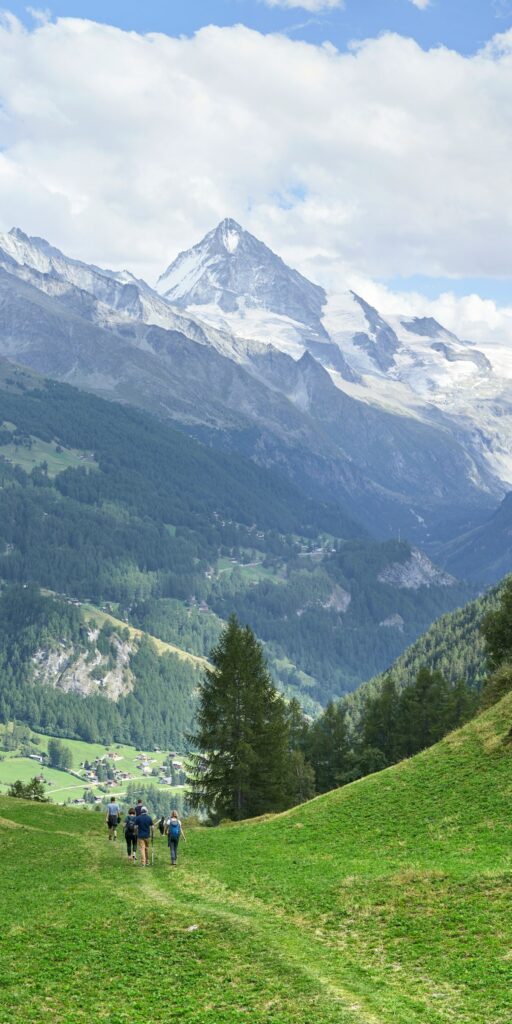 Hikers walk the trail in Val d'Hérens with the Dent Blanche in view