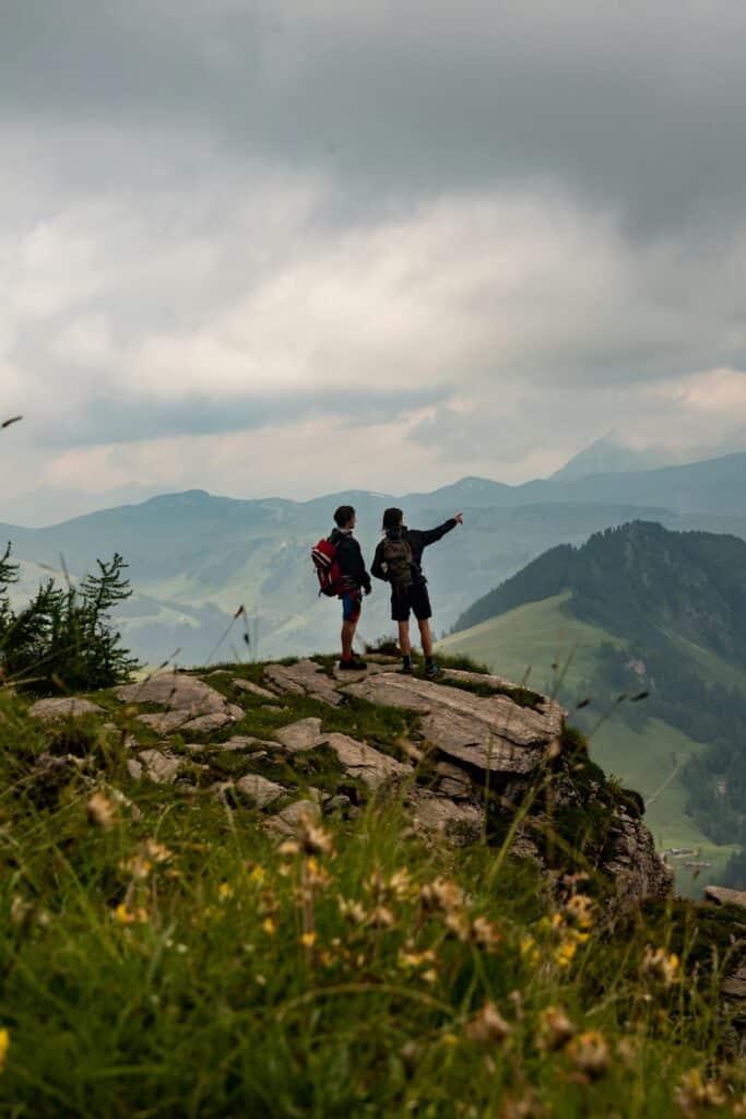 A traveler stands on a rocky outcrop in the Swiss Alps