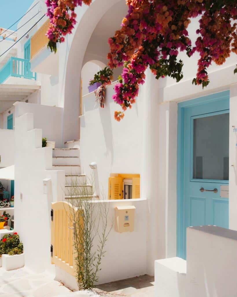 White house with a blue door and stone steps in Naxos