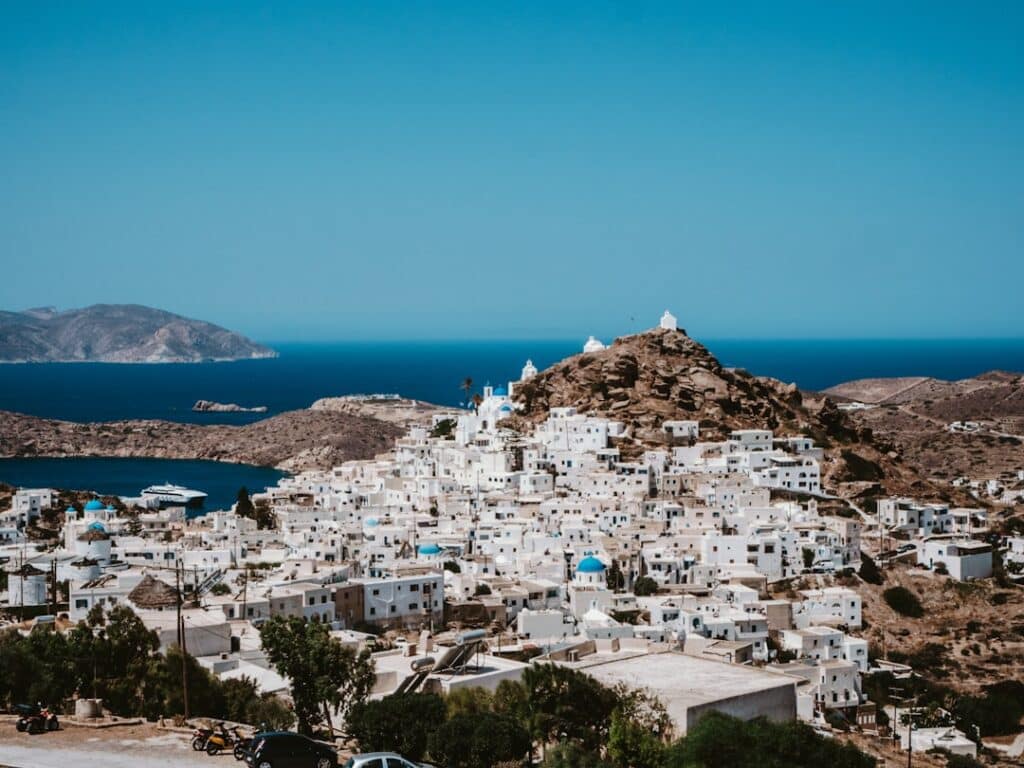 White and earth-toned houses clustered near the waterfront in the Cyclades