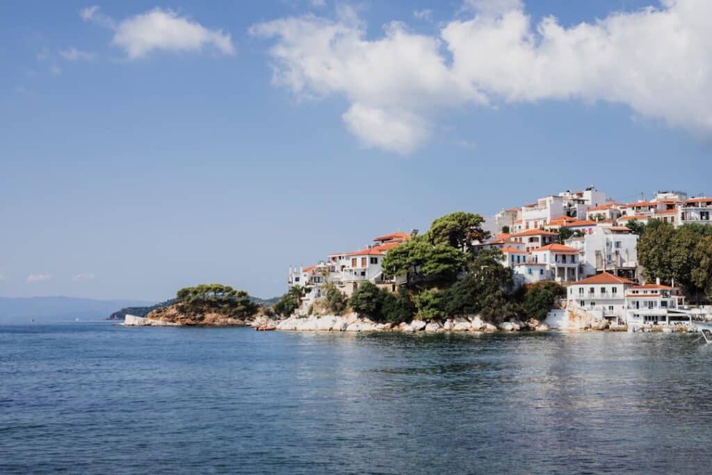 Pine-covered coastline of Skiathos with sailing boats on the water