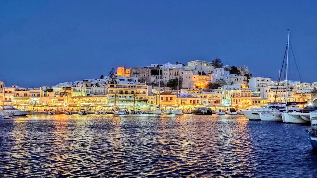Alternatives to Santorini: Less Crowded Greek Islands Worth Visiting 2 Naxos harbour lit up at night with hillside buildings above