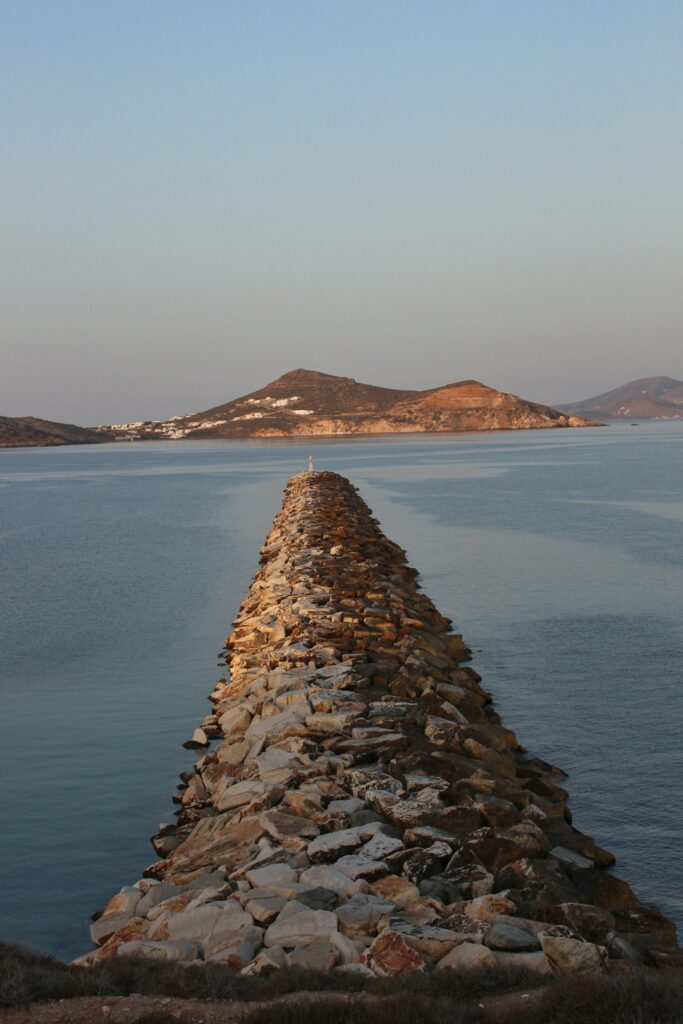 Alternatives to Santorini: Less Crowded Greek Islands Worth Visiting 13 Long stone wall extending into the sea on a Greek island