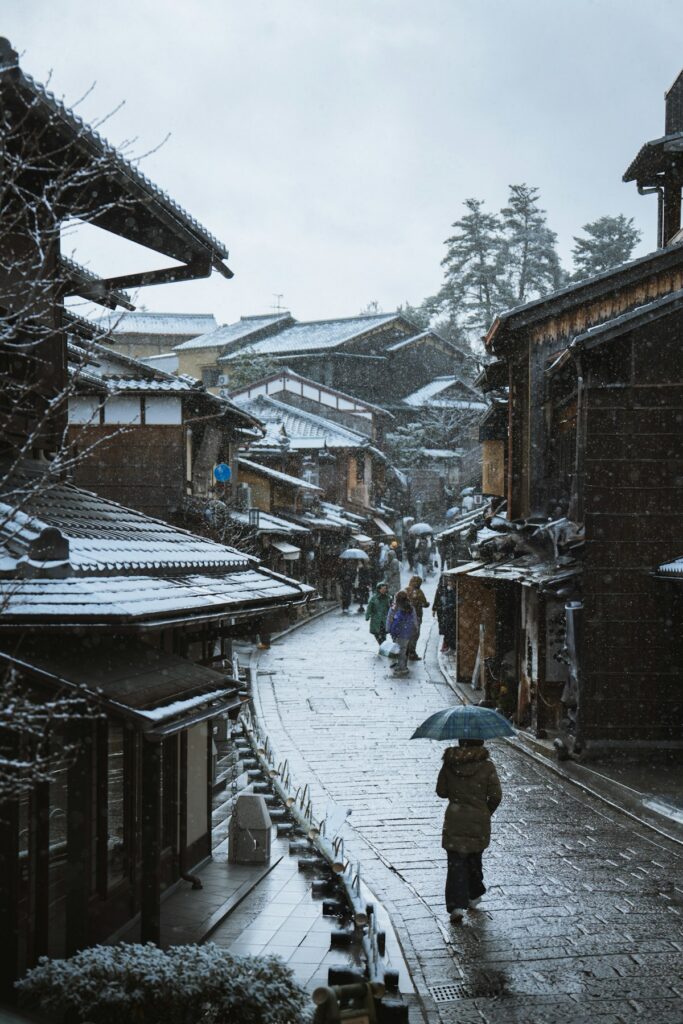 Snow covers a quiet street in Kyoto during winter