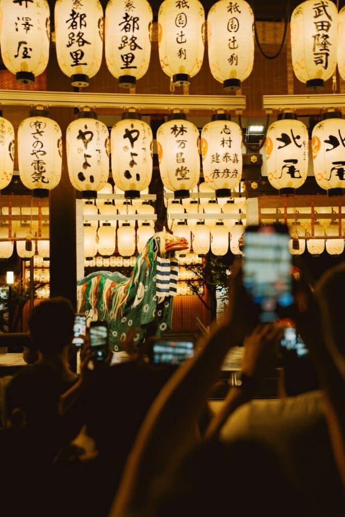 A crowd watches a lion dance performance beneath festival lanterns