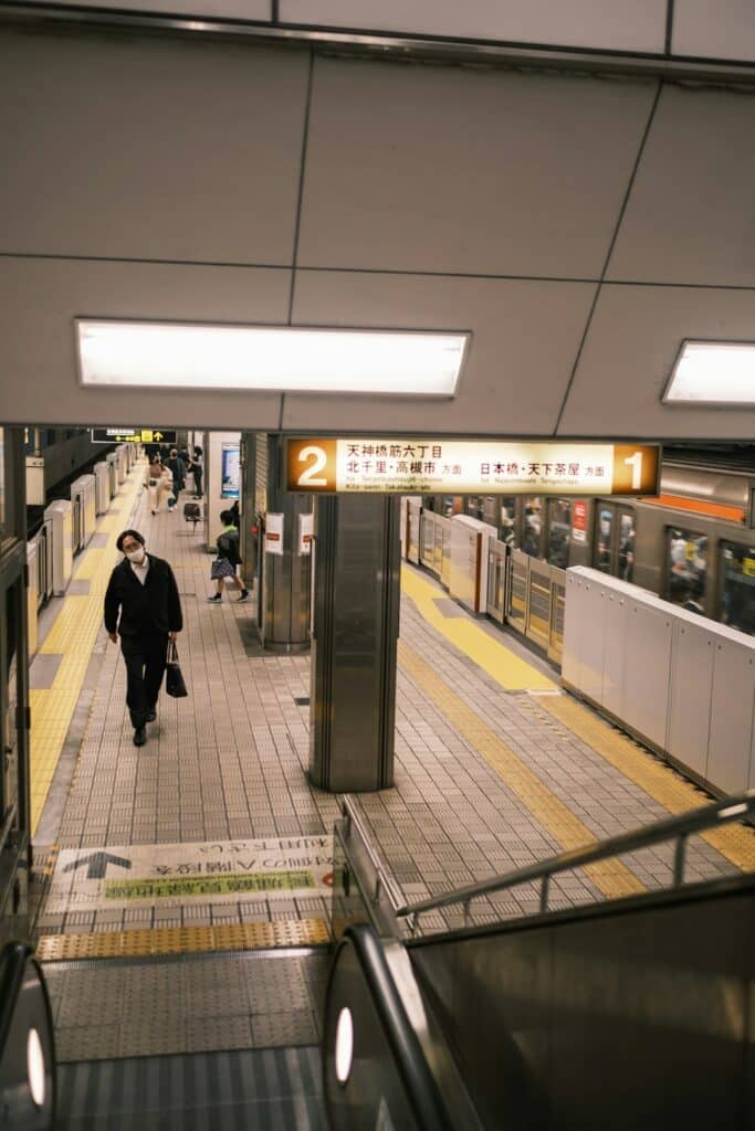 Do You Need a SIM Card in Japan? Your Data Options Explained (2026) 19 man walking along a subway platform beside an escalator