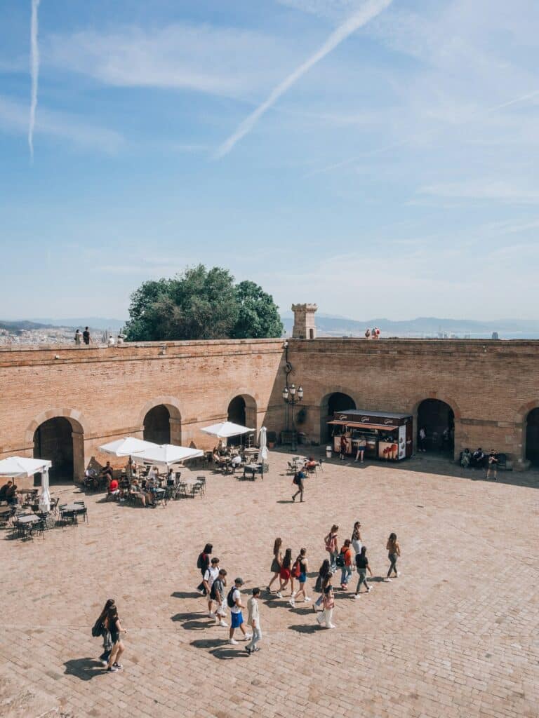 Visitors walking through a courtyard near Montjuïc