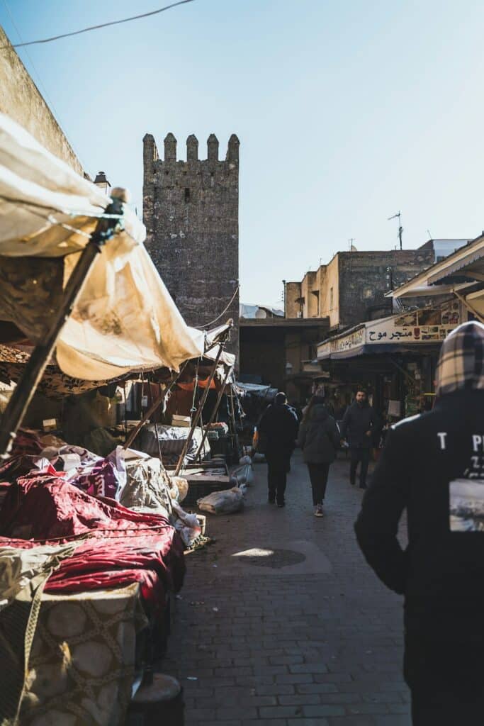 traveler walking down a Moroccan street while using a smartphone