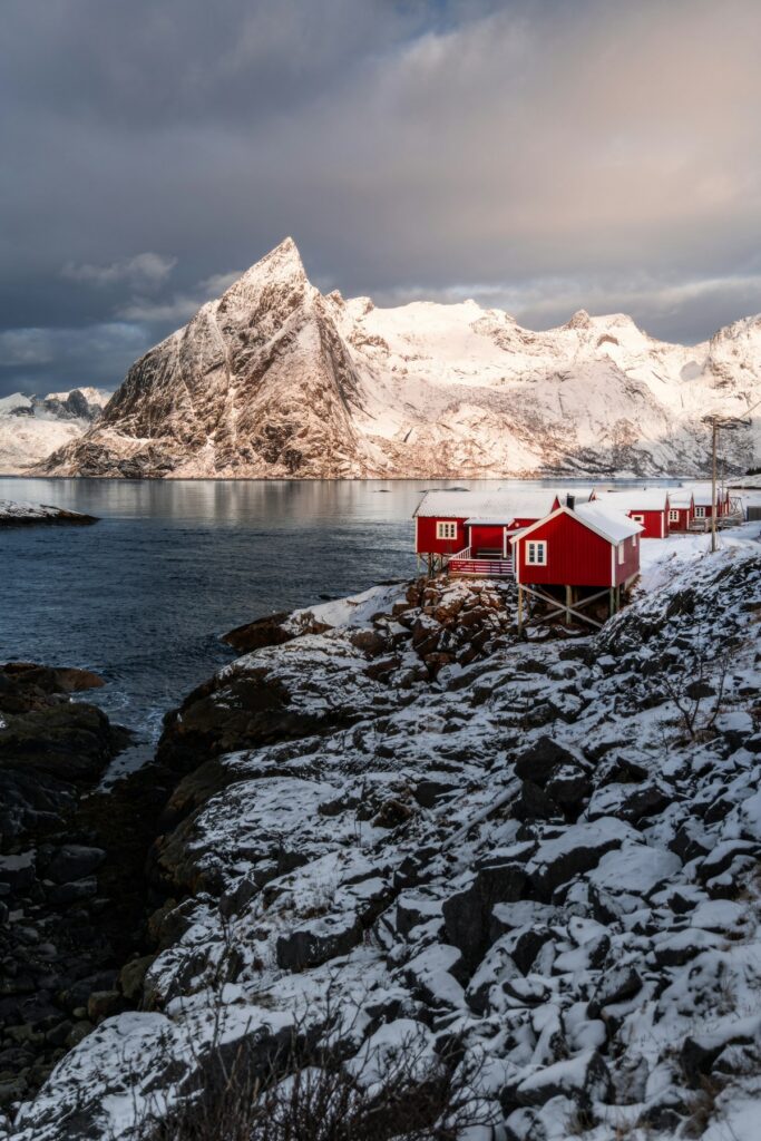 Red wooden cabins along a rocky Northern European coastline