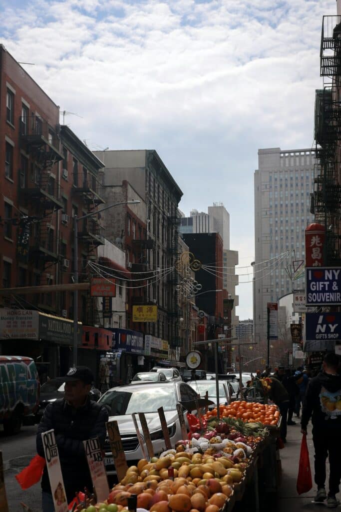 Busy street market with fruit stands in a New York neighbourhood
