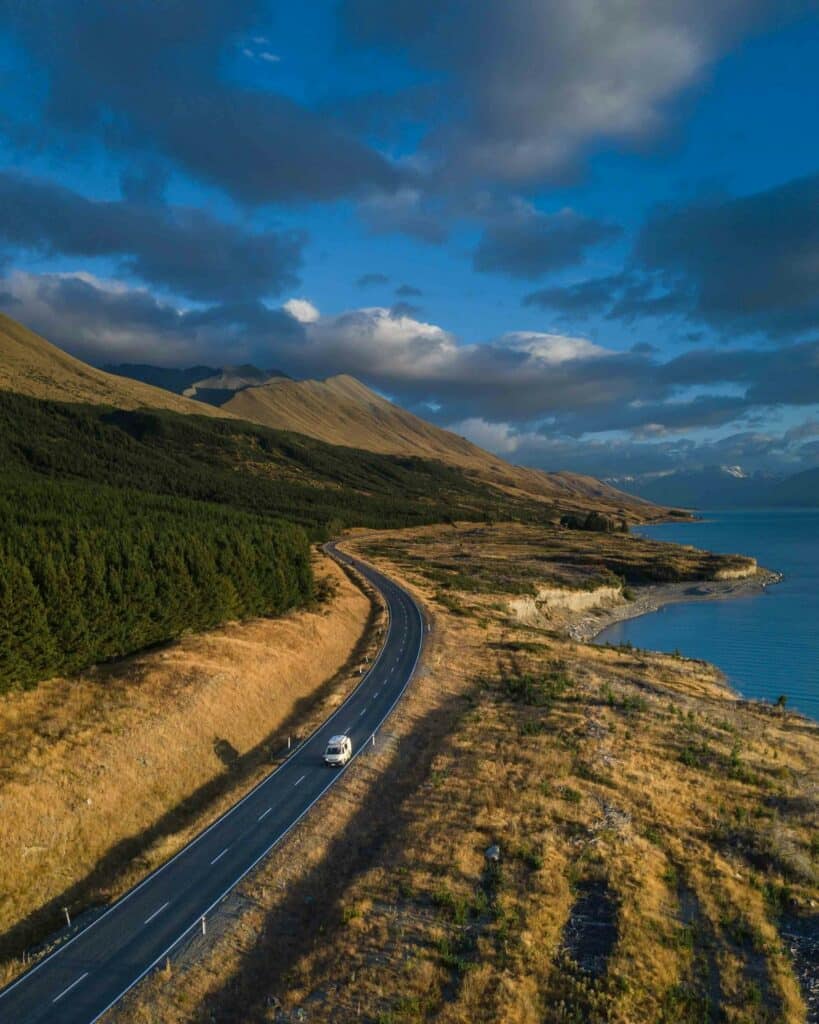 Best Internet Options for Travellers in New Zealand (2026) 11 rural road winding beside a lake in New Zealand