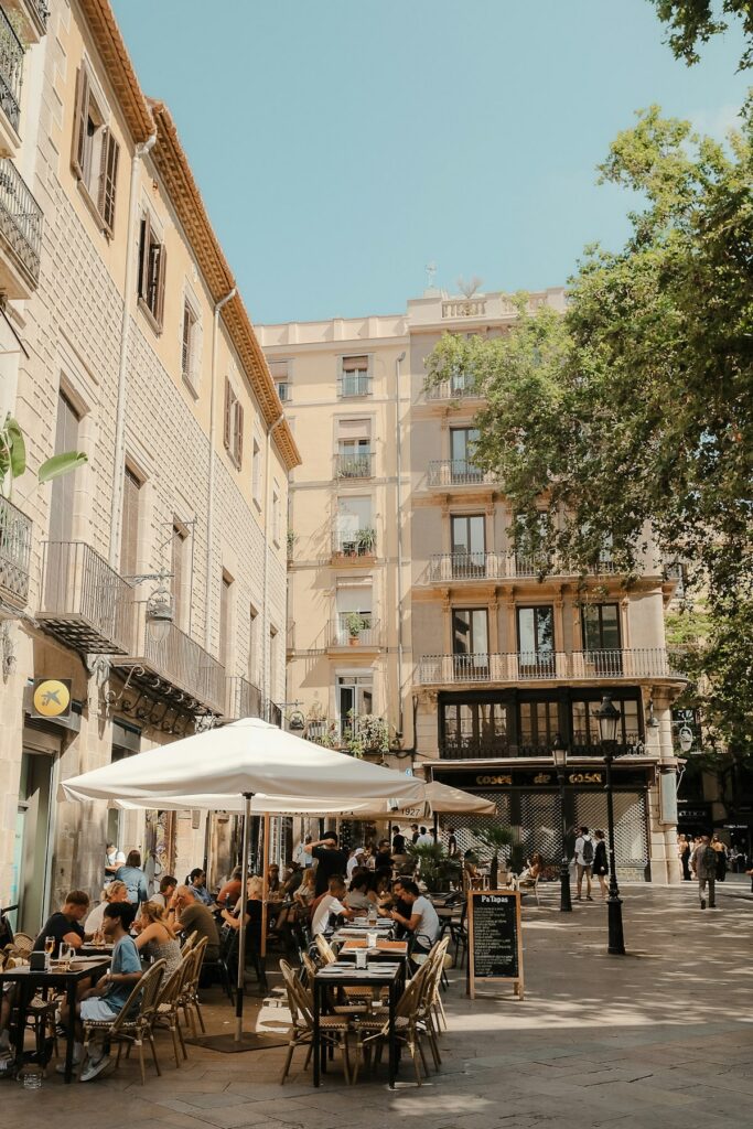 Diners seated at outdoor tables under umbrellas in Barcelona