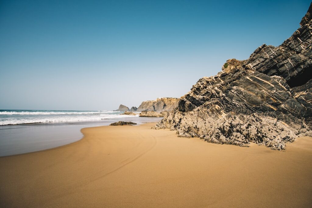 Best Beaches in Portugal: A Guide to the Country's Top Coastal Spots 10 Sandy Algarve beach framed by a rocky cliff on one side