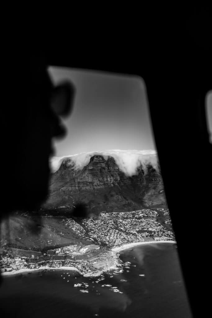 aerial view of a city beneath a cloud-covered mountain
