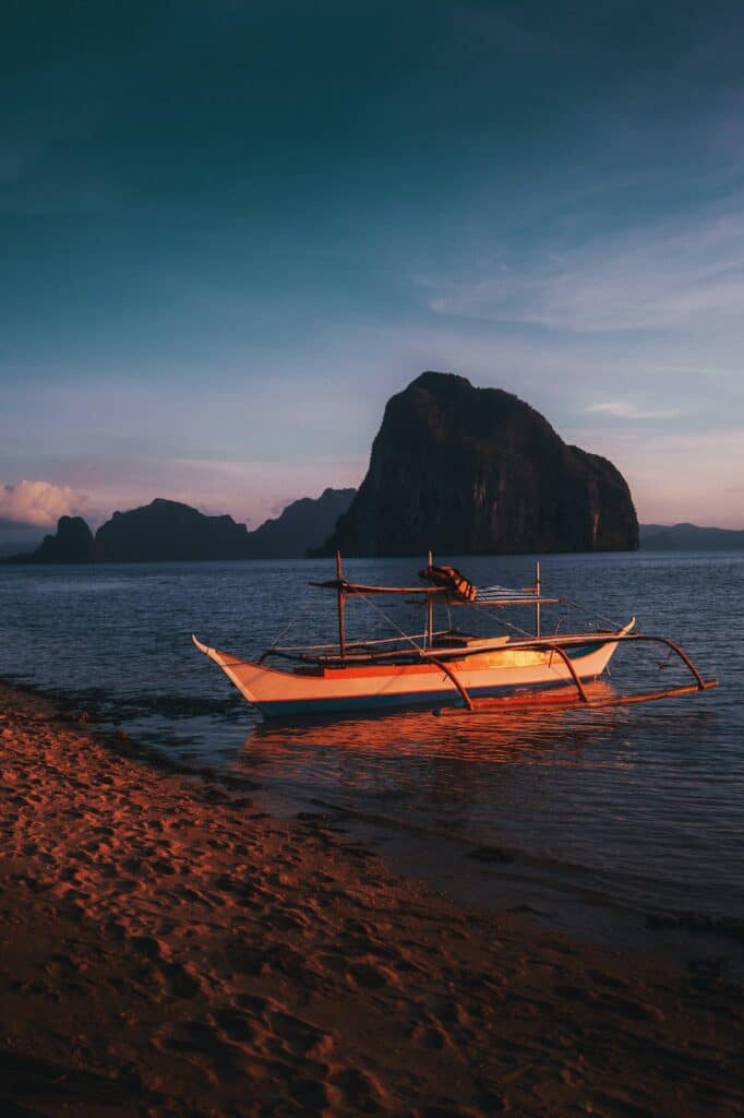 Where to Go in Southeast Asia in Summer: Best Destinations by Month 15 Traditional boat resting on a sandy Palawan beach