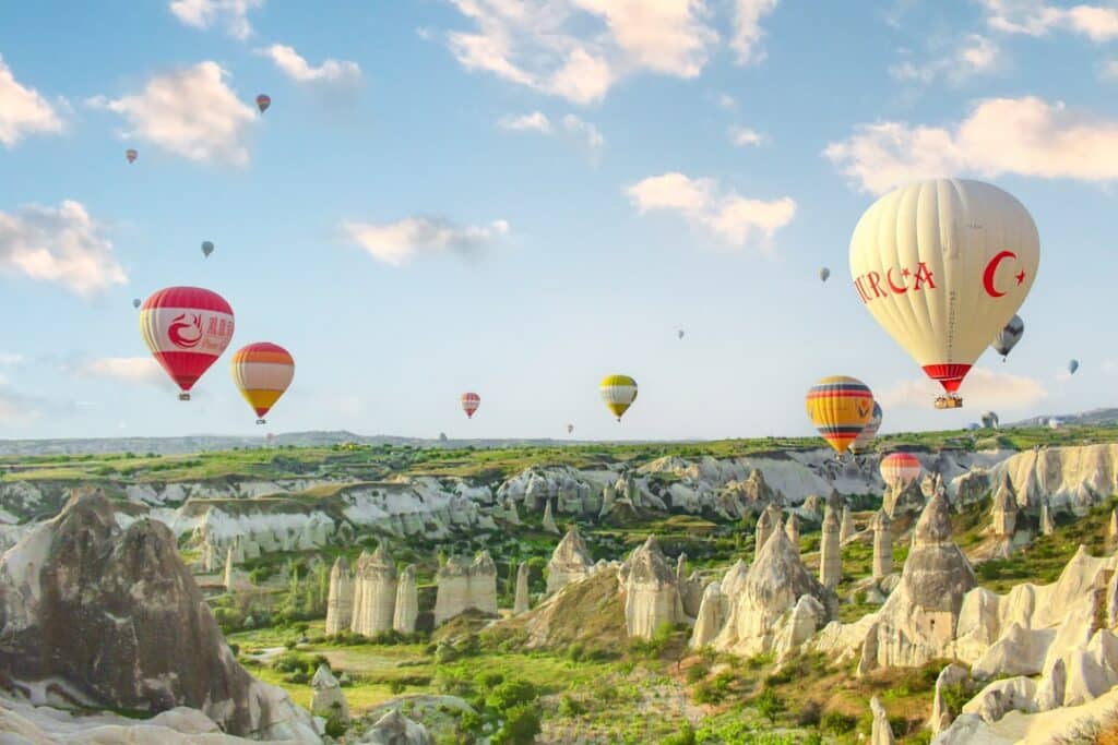 hot air balloon drifting over Cappadocia's rock landscape