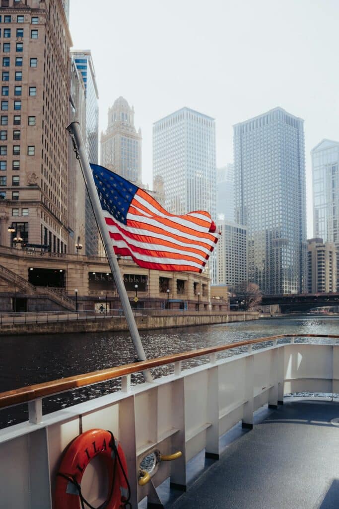 American flag waving above a city street