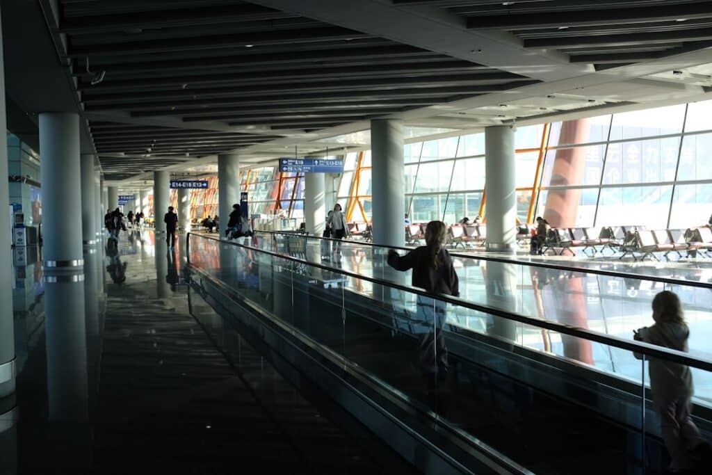 Travelers on an airport moving walkway preparing their internet USA tourist connection plan