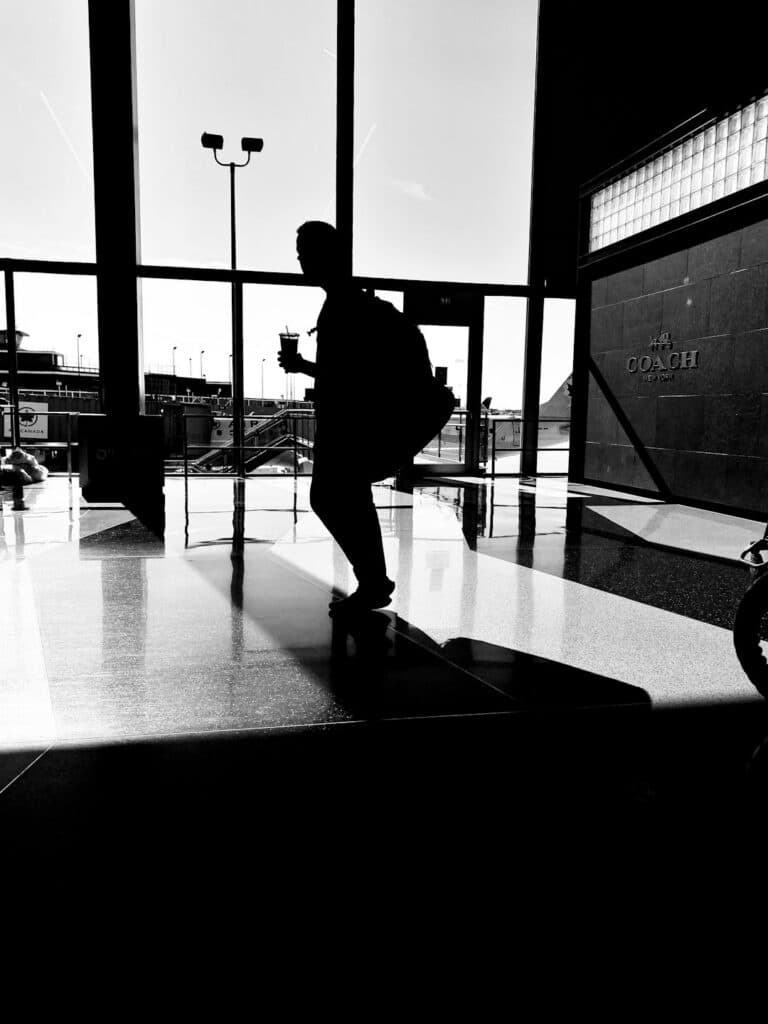 Traveler walking alone through an airport terminal corridor
