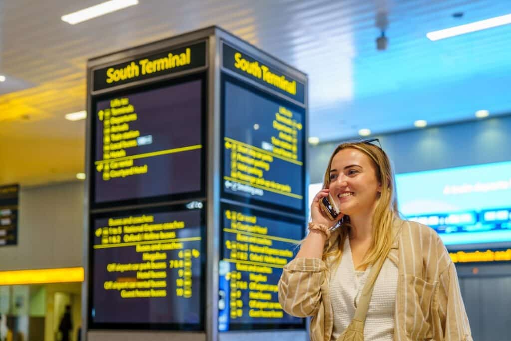 Woman on her phone in an airport arrivals area